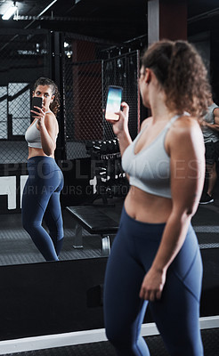 Buy stock photo Cropped shot of an attractive and athletic young woman taking selfies in the gym