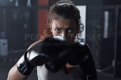 Buy stock photo Portrait of a young woman practicing her boxing routine at a gym