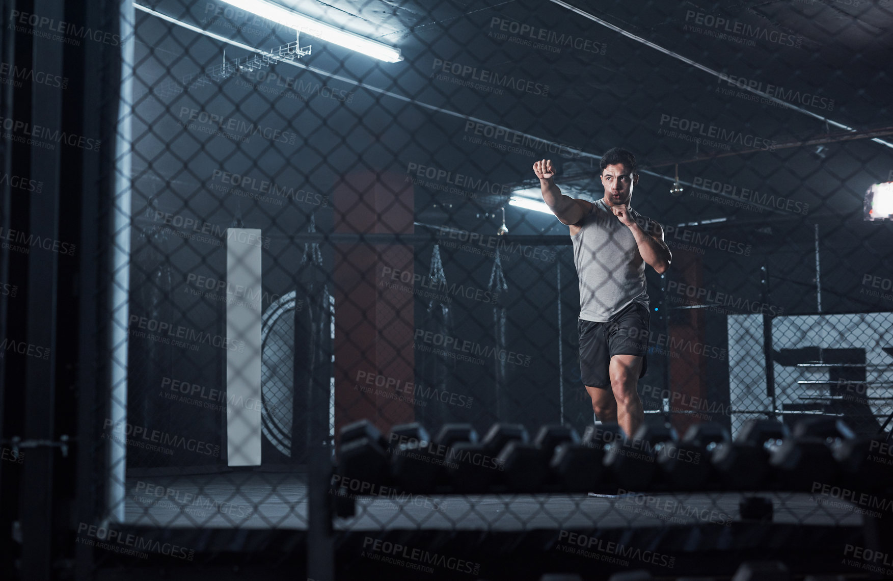 Buy stock photo Shot of a young man practicing his kickboxing routine at a gym