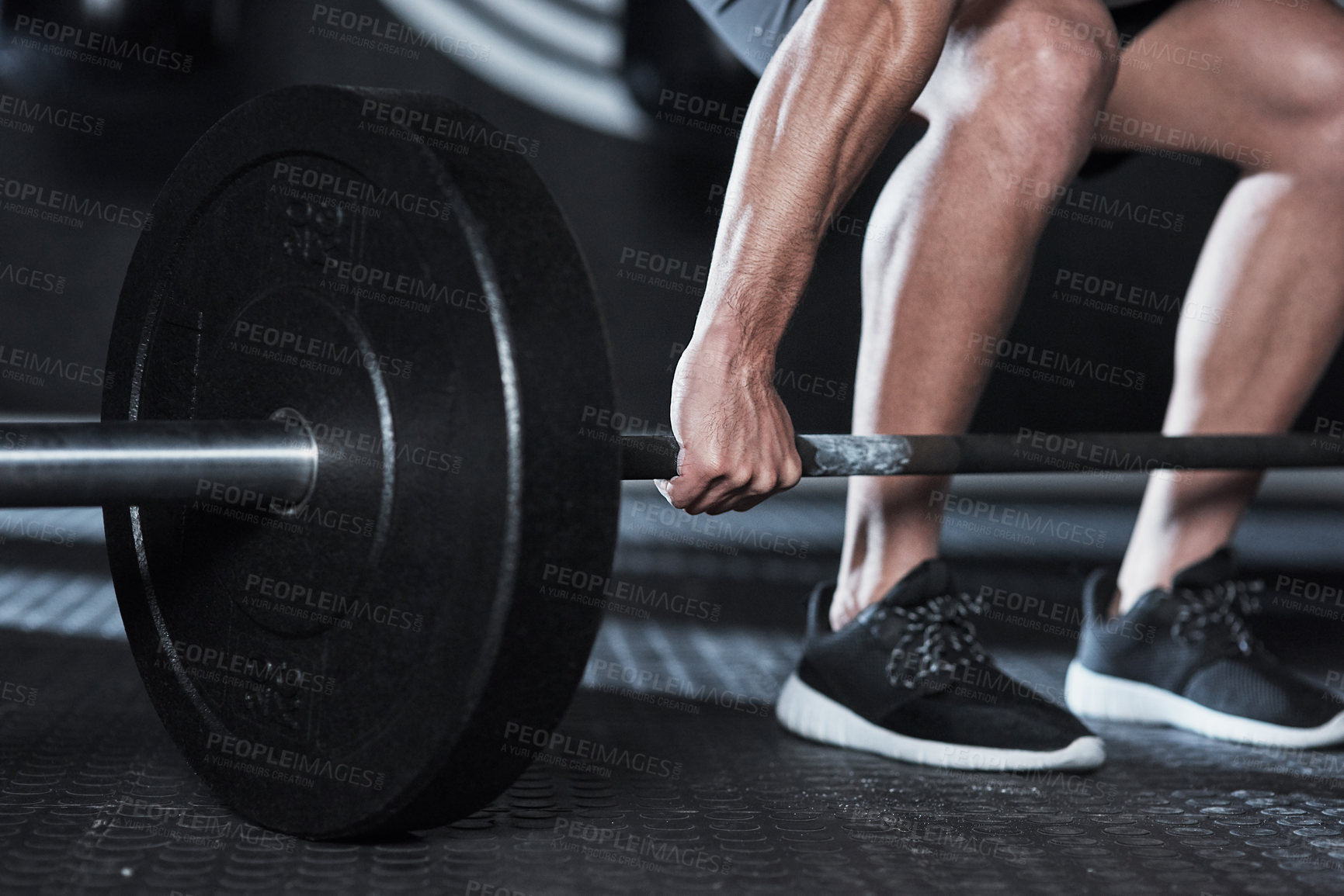 Buy stock photo Shot of an unrecognisable man lifting a barbell during his workout at a gym