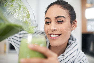 Buy stock photo Cropped shot of a woman drinking a smoothie at home