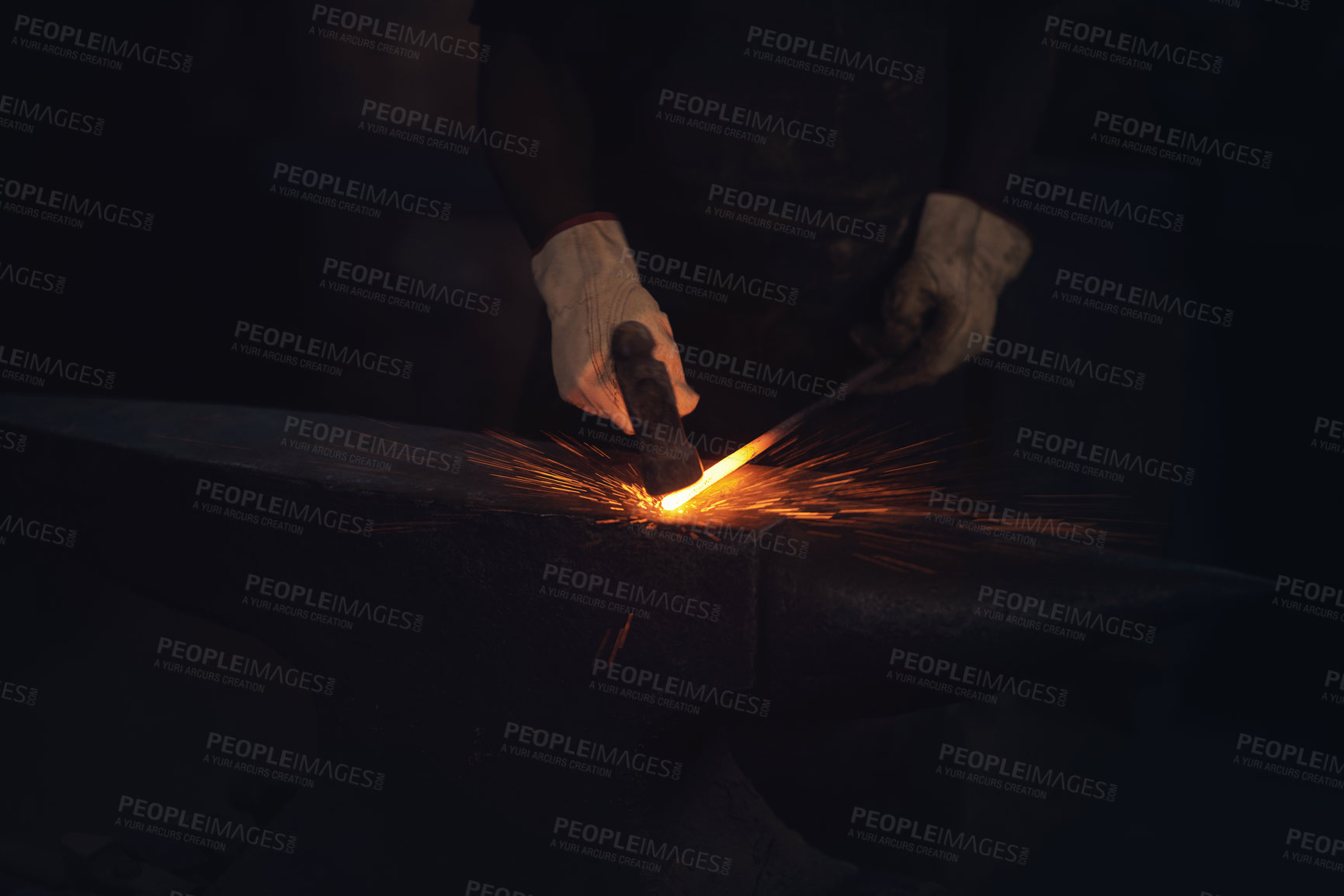Buy stock photo Shot of a blacksmith hitting a hot metal rod with a hammer in a foundry