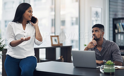 Buy stock photo Shot of a young businessman gesturing for his colleague to be quiet in an office