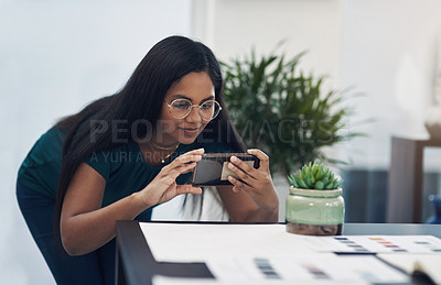 Buy stock photo Shot of a young designer taking photos of her work in an office
