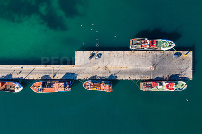 Buy stock photo High angle shot of boats docked alongside a pier