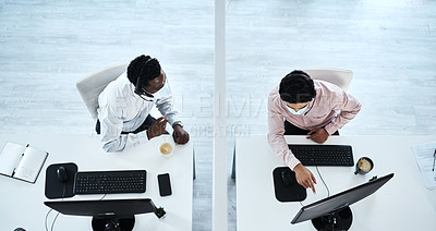 Buy stock photo High angle shot of two call centre agents working together in an office