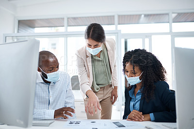 Buy stock photo Shot of a group of businesspeople wearing face masks while going through paperwork together in an office