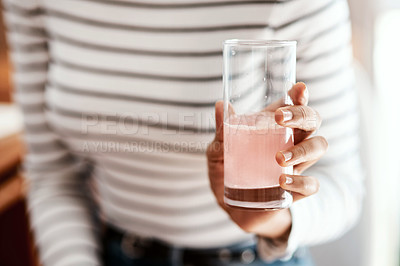 Buy stock photo Cropped shot of a woman having an effervescent drink at home