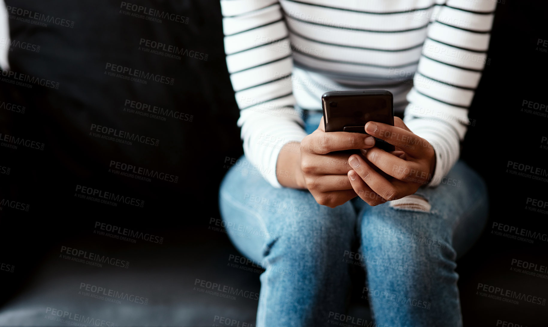 Buy stock photo Cropped shot of a woman using a smartphone on the sofa at home