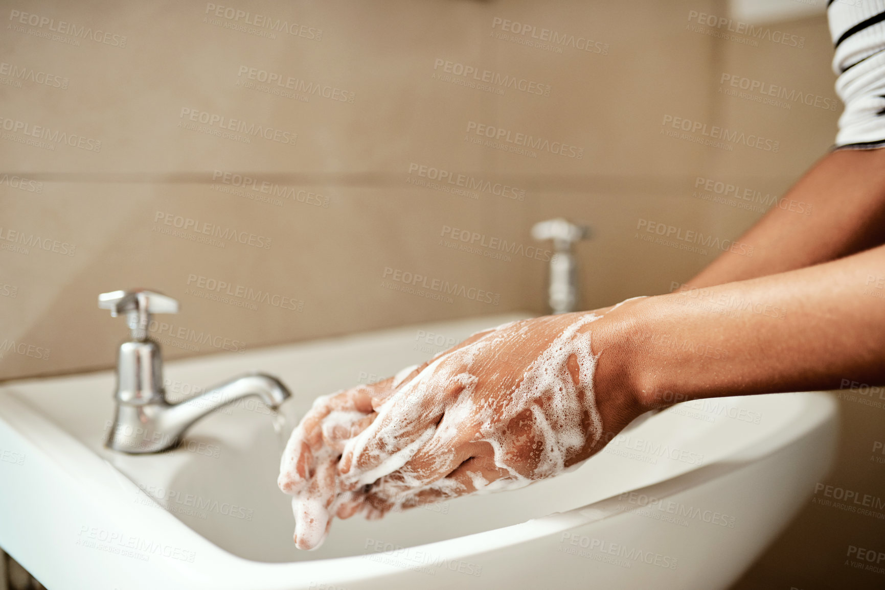 Buy stock photo Cropped shot of a woman washing her hands with soap in the bathroom sink at home