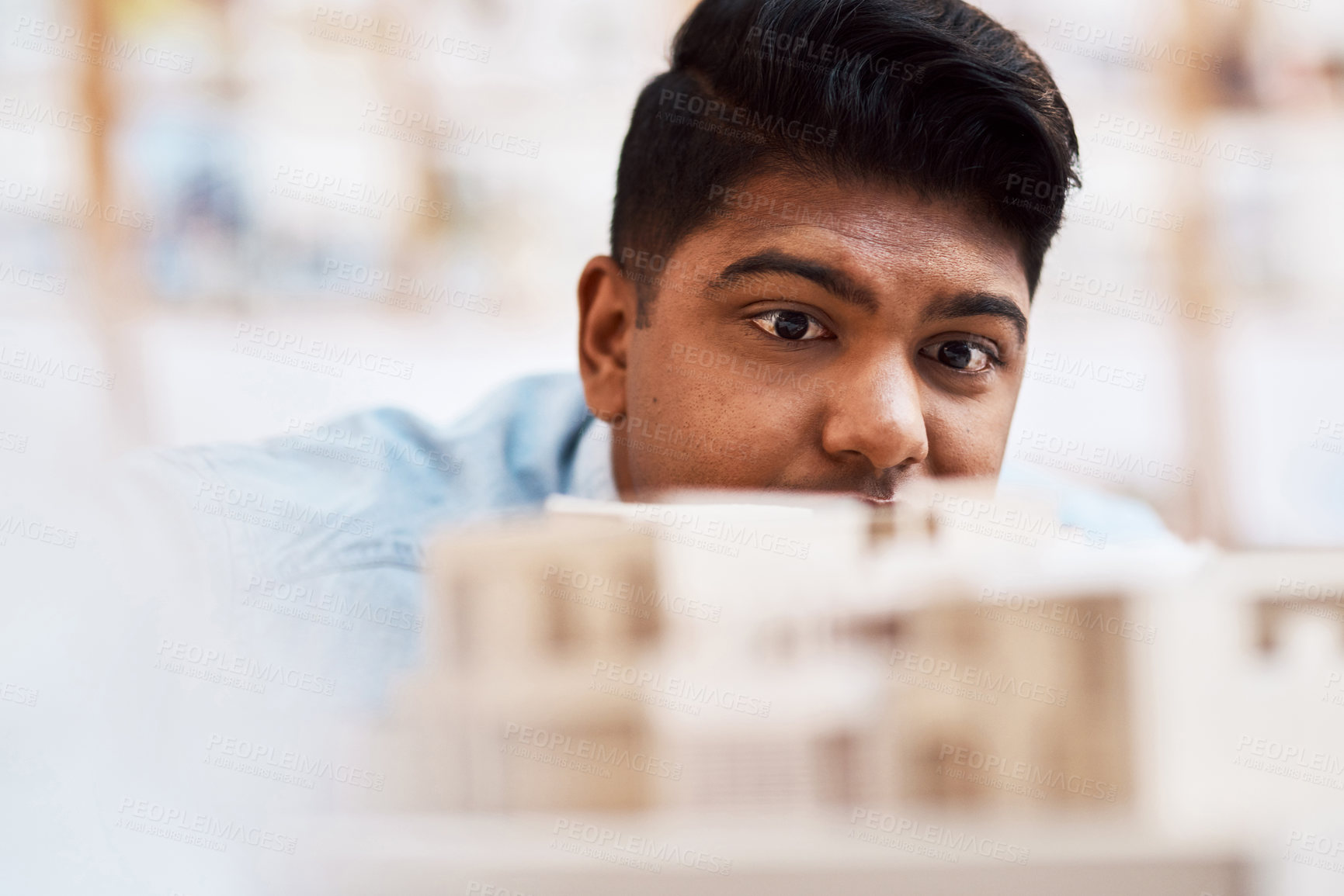 Buy stock photo Shot of a young architect designing a building model in a modern office