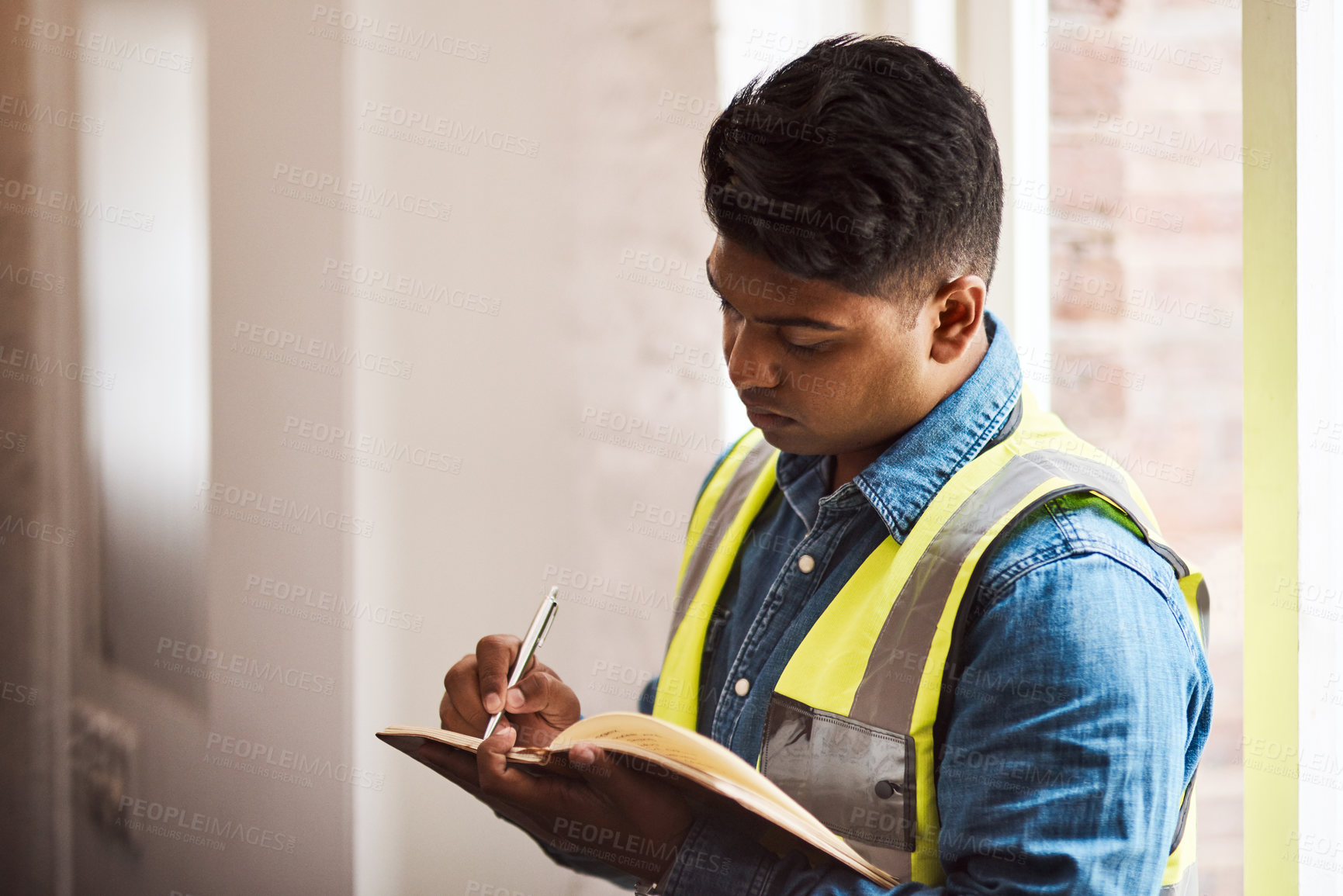 Buy stock photo Shot of a engineer making notes while on a construction site