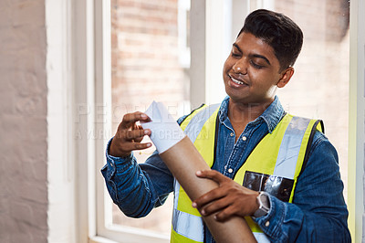 Buy stock photo Shot of a young engineer holding a blueprint
