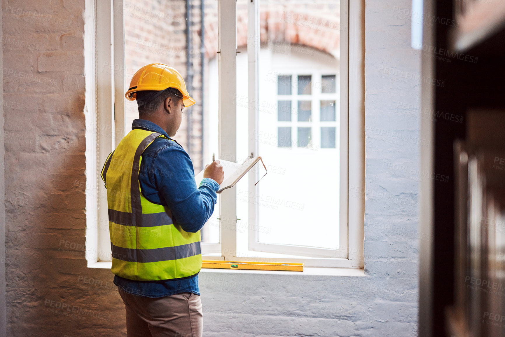Buy stock photo Shot of a engineer making notes while on a construction site