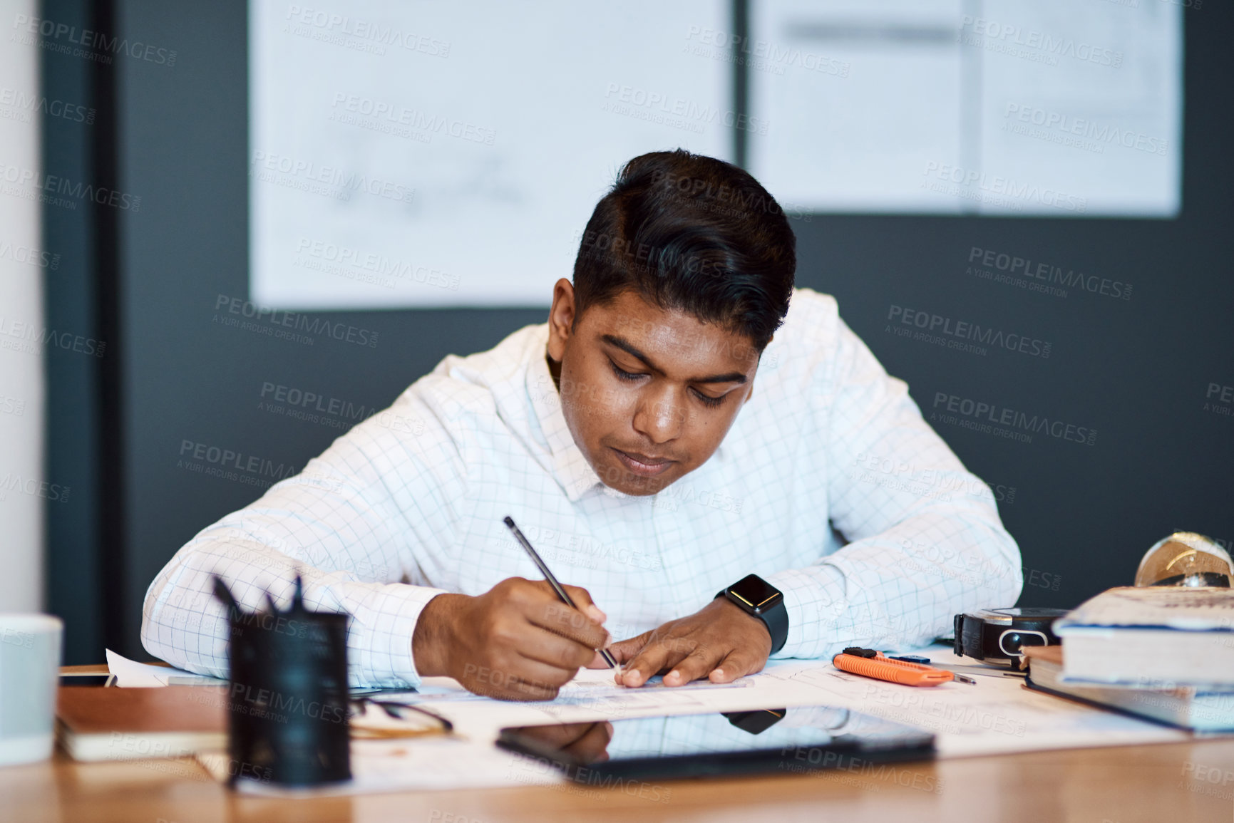 Buy stock photo Shot of an architect using a ruler to draw a building plan