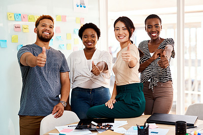 Buy stock photo Portrait of a group of young creatives showing thumbs up together in an office