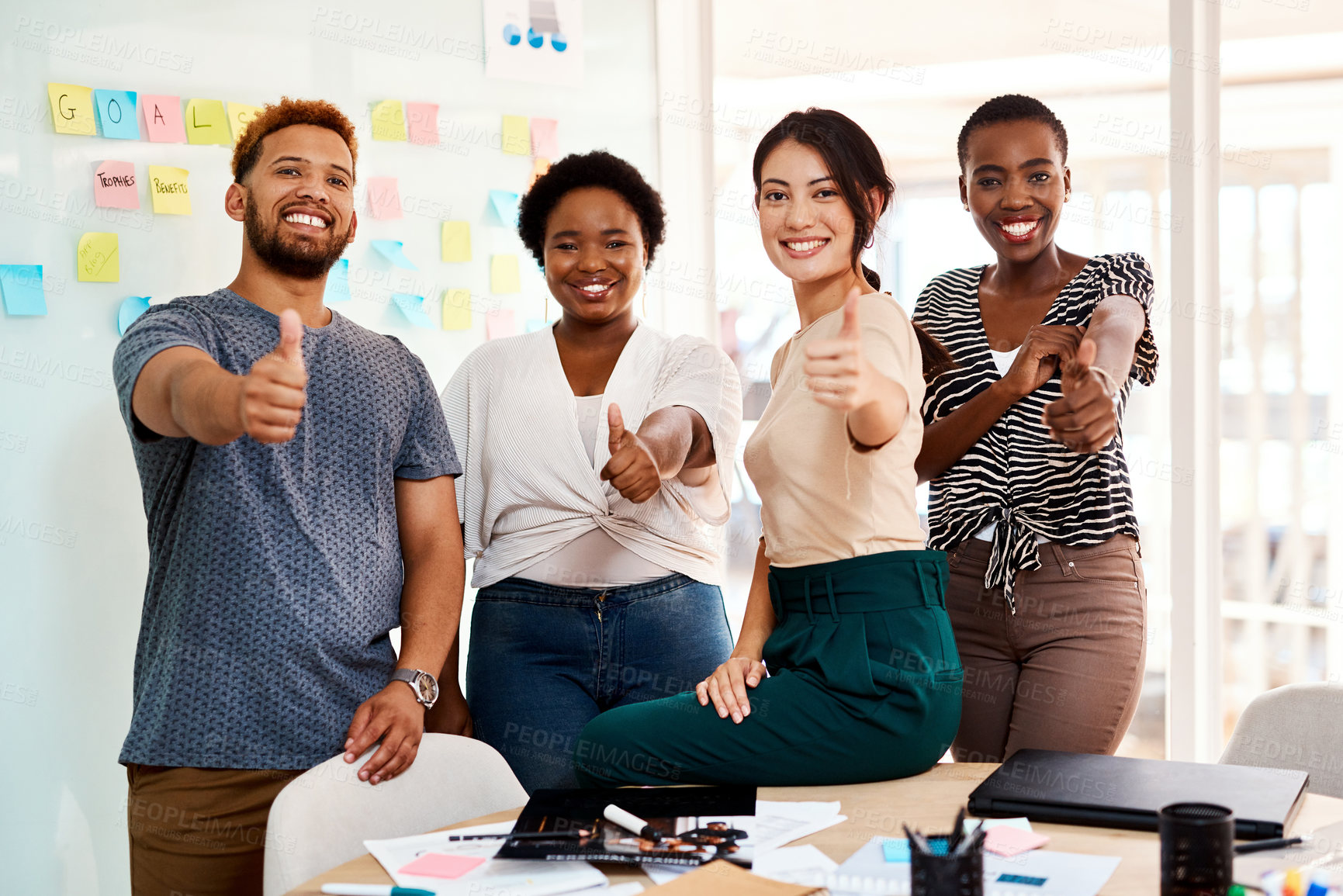 Buy stock photo Portrait of a group of young creatives showing thumbs up together in an office