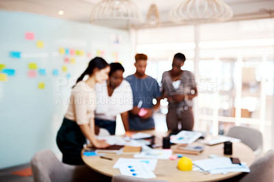 Buy stock photo Defocused shot of a group of young creatives working together in an office