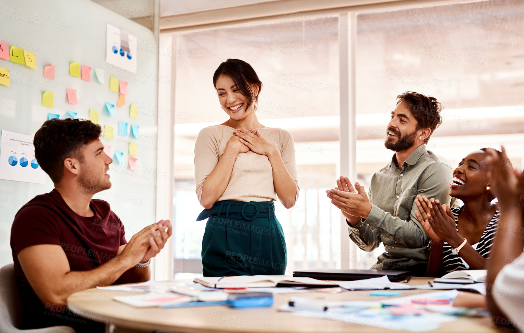 Buy stock photo Shot of a group of young creatives applauding a colleague during a meeting in an office