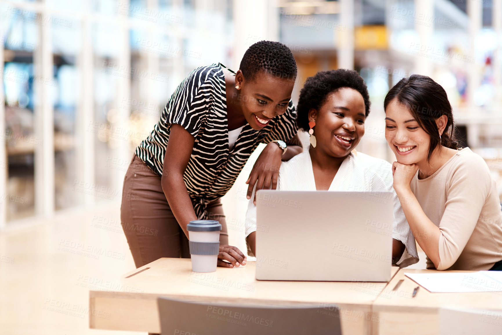 Buy stock photo Shot of a group of businesswomen working on a laptop together in an office