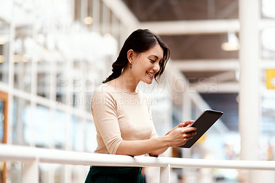 Buy stock photo Shot of a young businesswoman using a digital tablet in an office