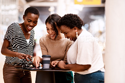 Buy stock photo Shot of a group of businesswomen using a digital tablet together in an office