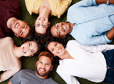 Buy stock photo Portrait of a group of young creatives showing lying down in a huddle together
