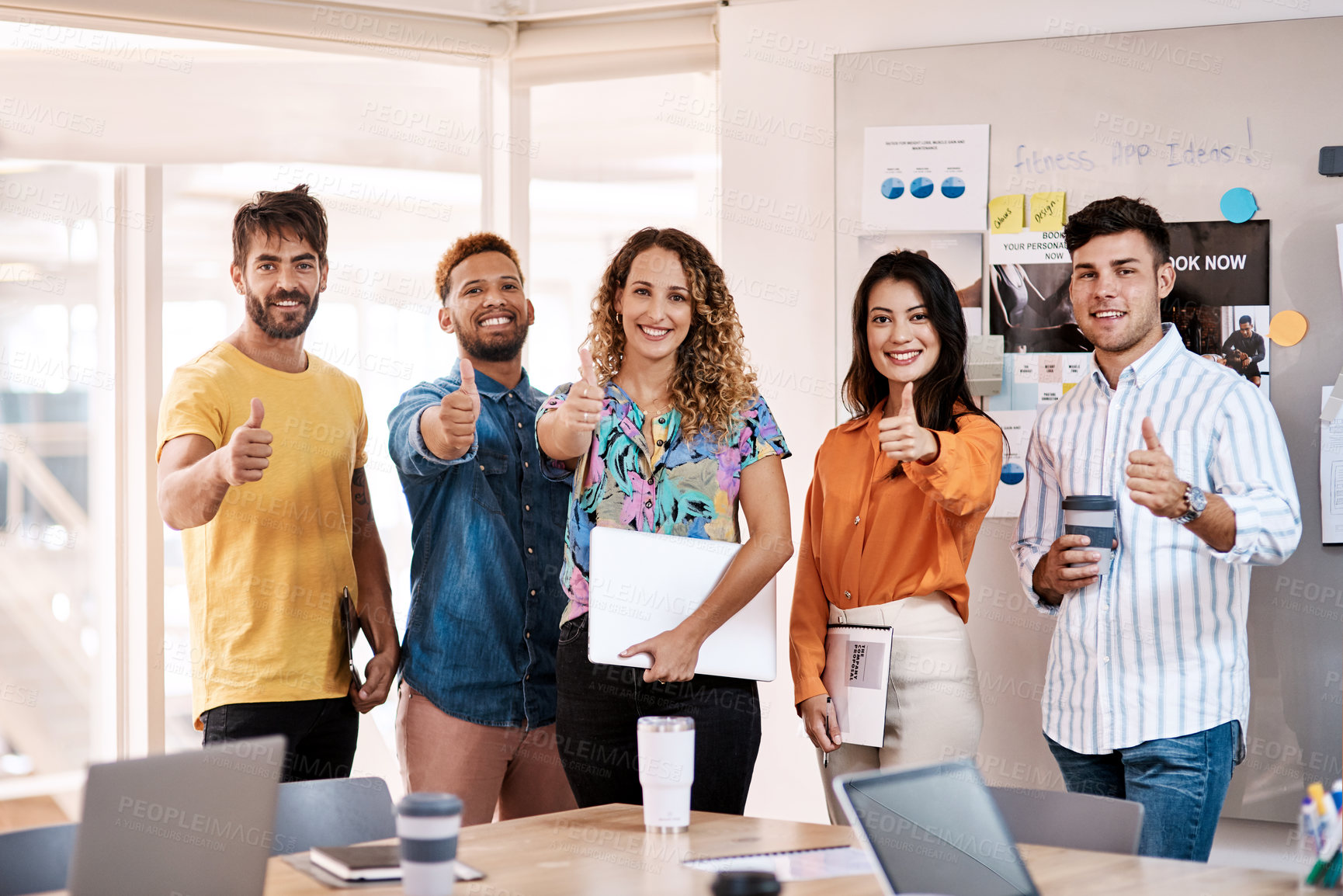 Buy stock photo Cropped portrait of a group of young designers giving thumbs up to the camera while standing in the boardroom of their office