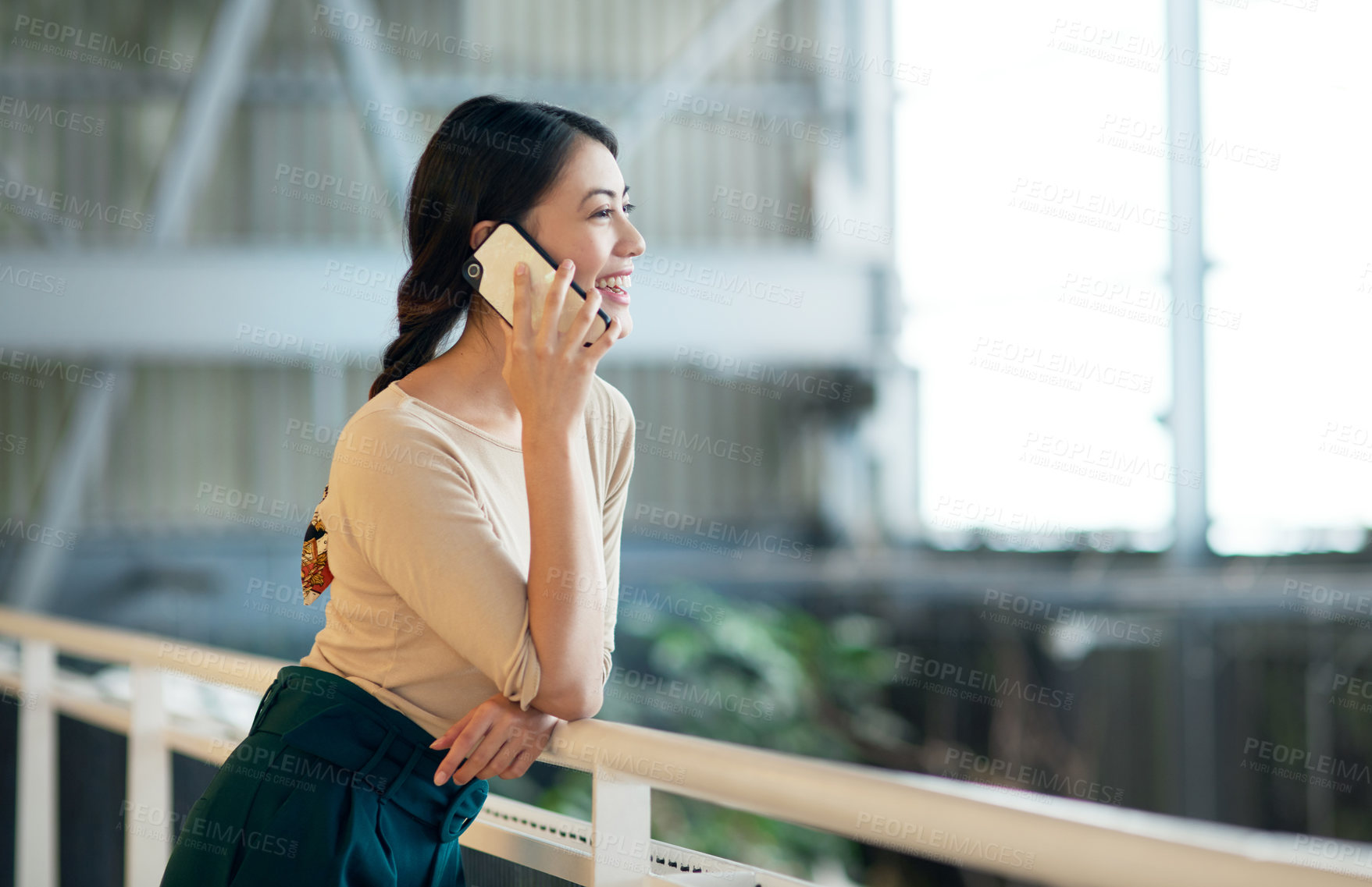 Buy stock photo Shot of a young businesswoman talking on a cellphone in an office