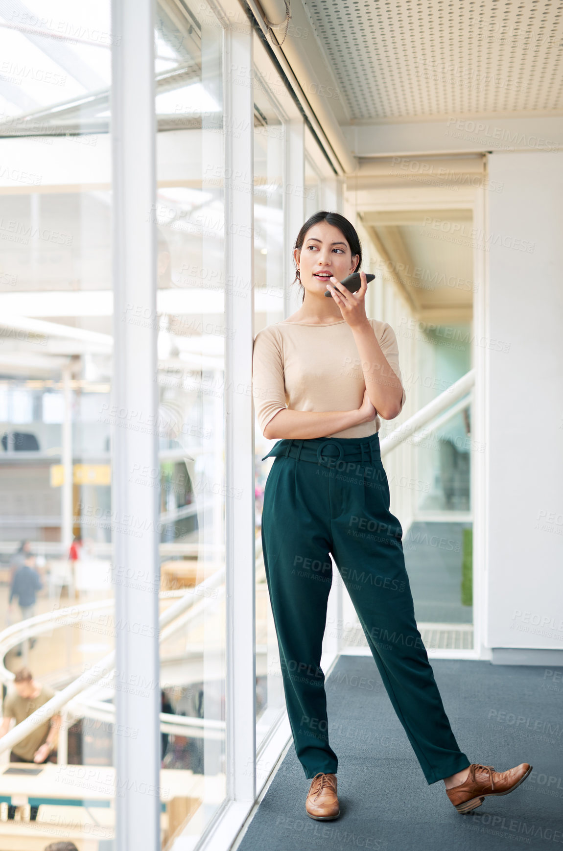 Buy stock photo Shot of a young businesswoman using a cellphone in an office