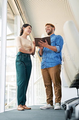 Buy stock photo Shot of two businesspeople going through a notebook together in an office