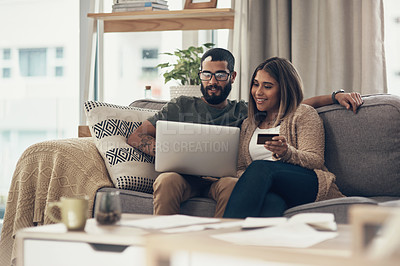 Buy stock photo Shot of a young couple using a laptop and credit card at home