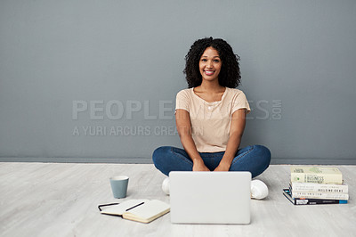 Buy stock photo Studio shot of a young woman using a laptop while completing her studies against a gray background