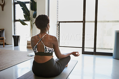 Buy stock photo Rearview shot of a young woman meditating at home