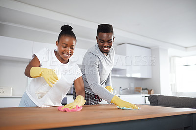 Buy stock photo Shot of a young couple cleaning the kitchen counter at home
