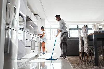 Buy stock photo Shot of a young couple cleaning the kitchen at home