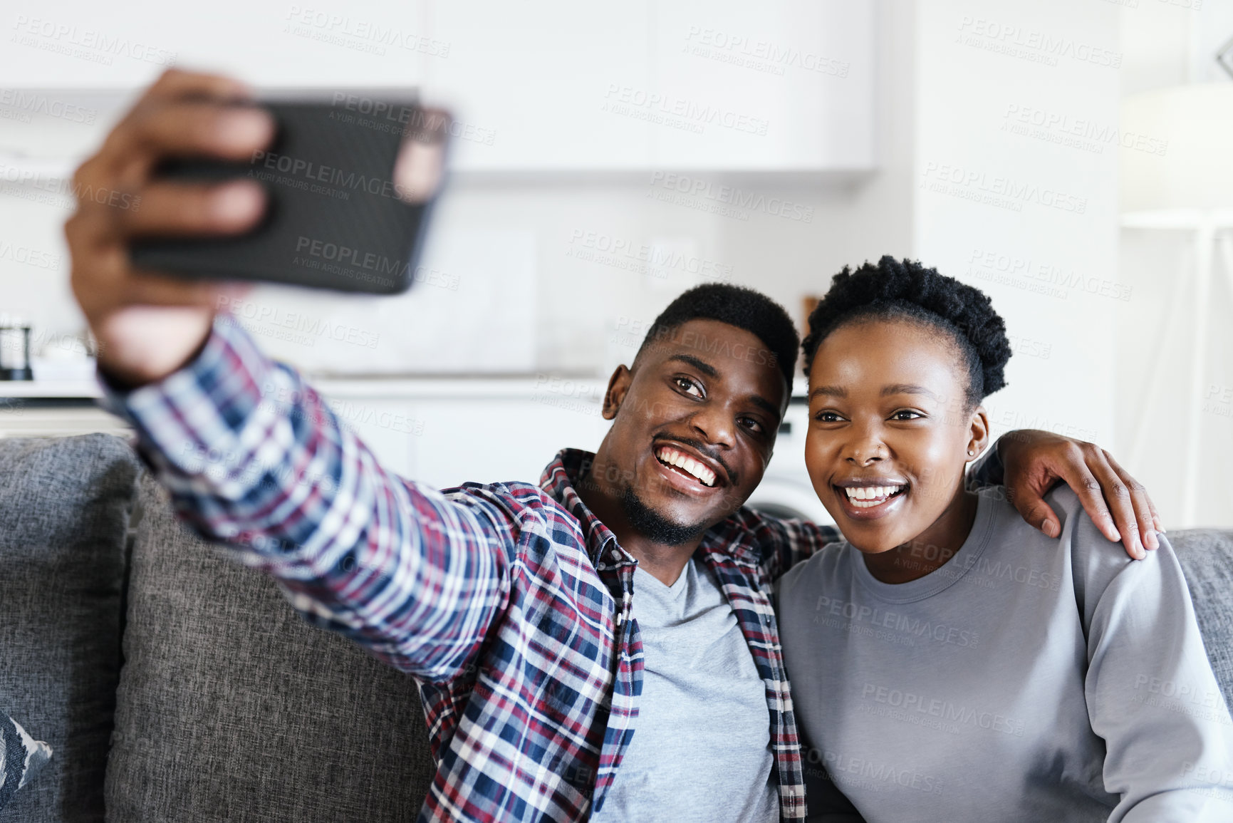 Buy stock photo Shot of a young couple taking selfies together at home