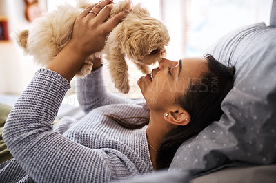 Buy stock photo Shot of a young woman relaxing with her dog at home