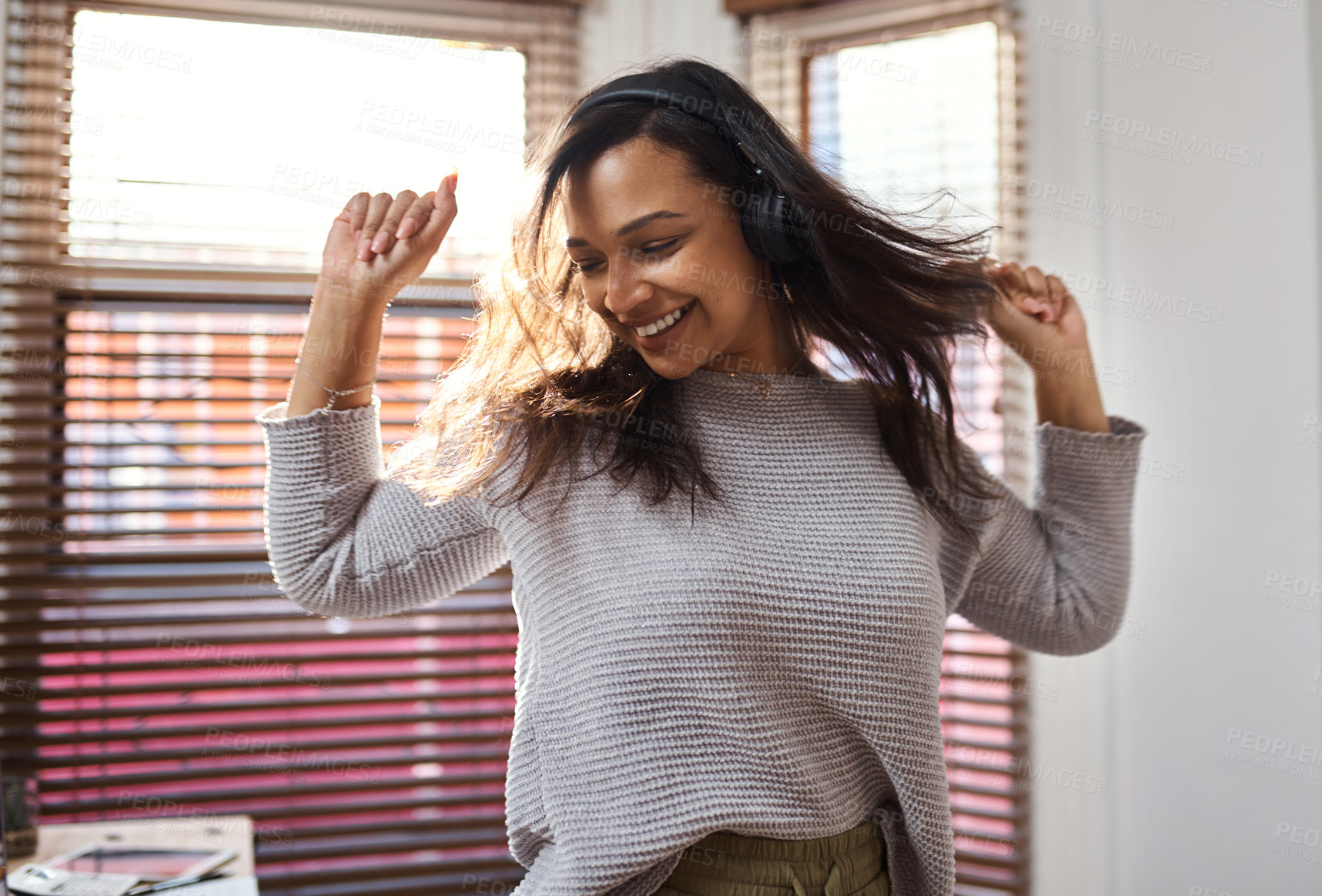 Buy stock photo Shot of a young woman dancing while listening to music at home