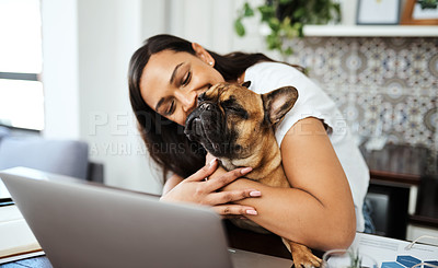 Buy stock photo Shot of a young woman sitting with her pet dog on her lap while working from home