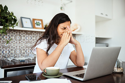 Buy stock photo Shot of a young woman looking stressed out while working on a laptop at home