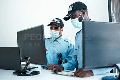 Buy stock photo Shot of two masked young security guards on duty at the front desk of an office