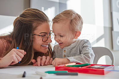 Buy stock photo Shot of a woman and her young son using crayons to draw at home