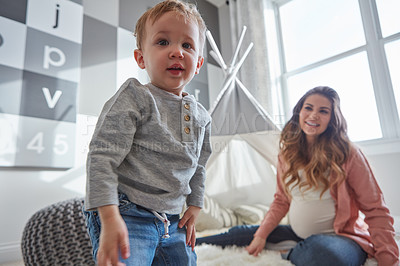 Buy stock photo Shot of a pregnant woman bonding with her toddler son at home