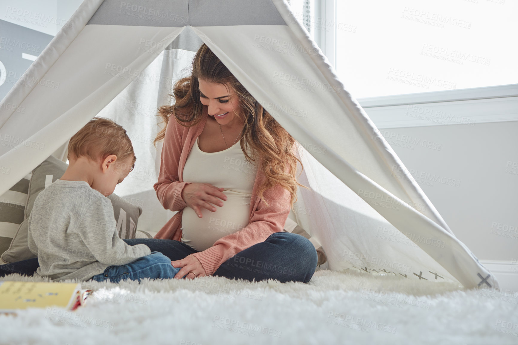 Buy stock photo Shot of a pregnant woman bonding with her toddler son at home