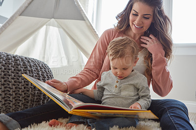 Buy stock photo Shot of a woman reading to her toddler son at home