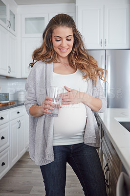 Buy stock photo 4k video footage of a pregnant woman drinking a glass of water at home