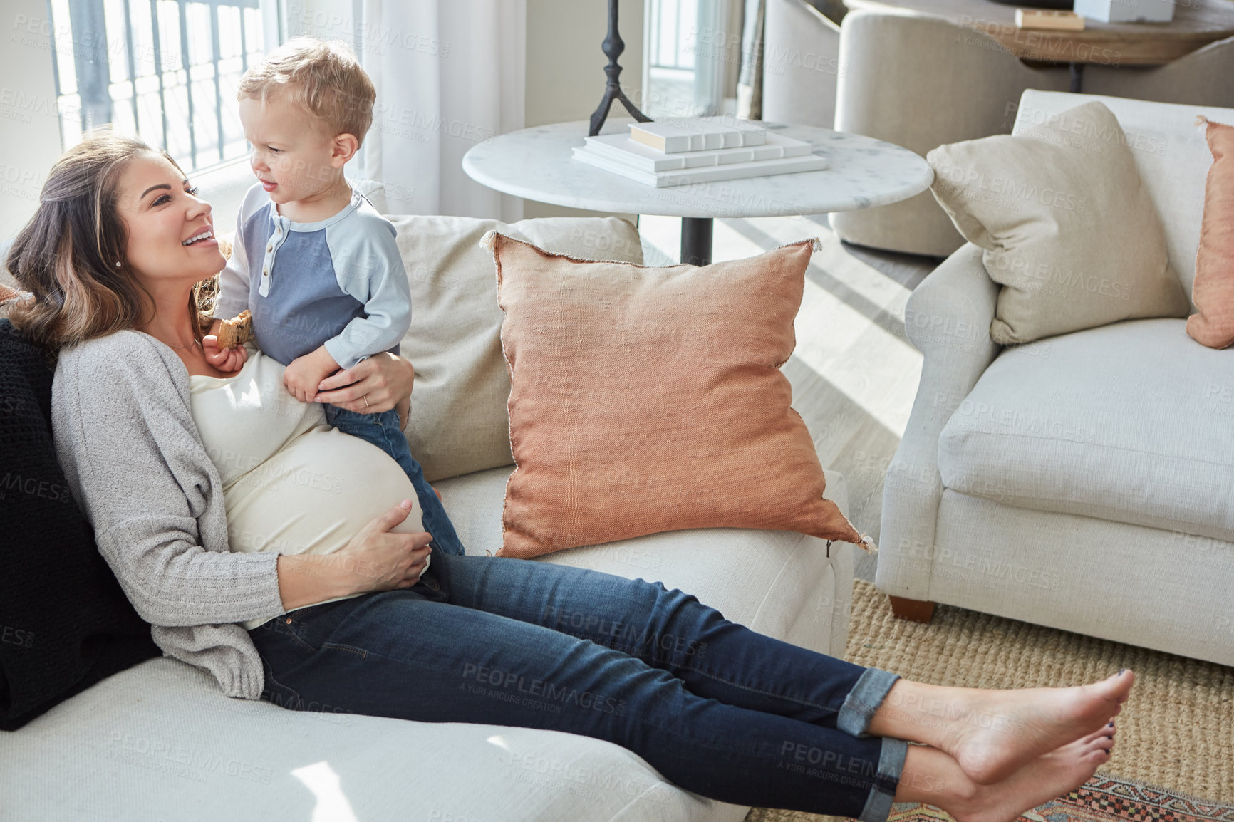 Buy stock photo Shot of a pregnant woman bonding with her toddler son at home