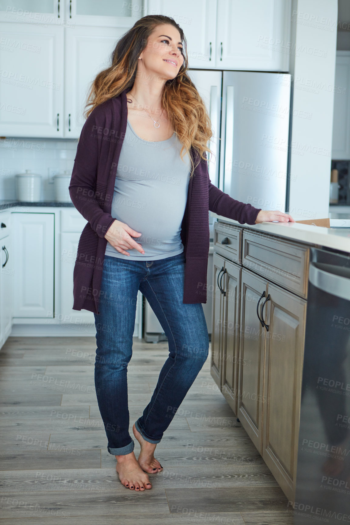 Buy stock photo Full length shot of an attractive young pregnant woman standing in her kitchen at home