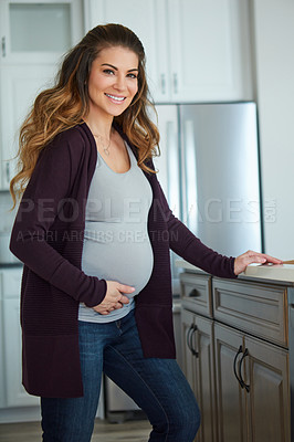 Buy stock photo Cropped portrait of an attractive young pregnant woman standing in her kitchen at home